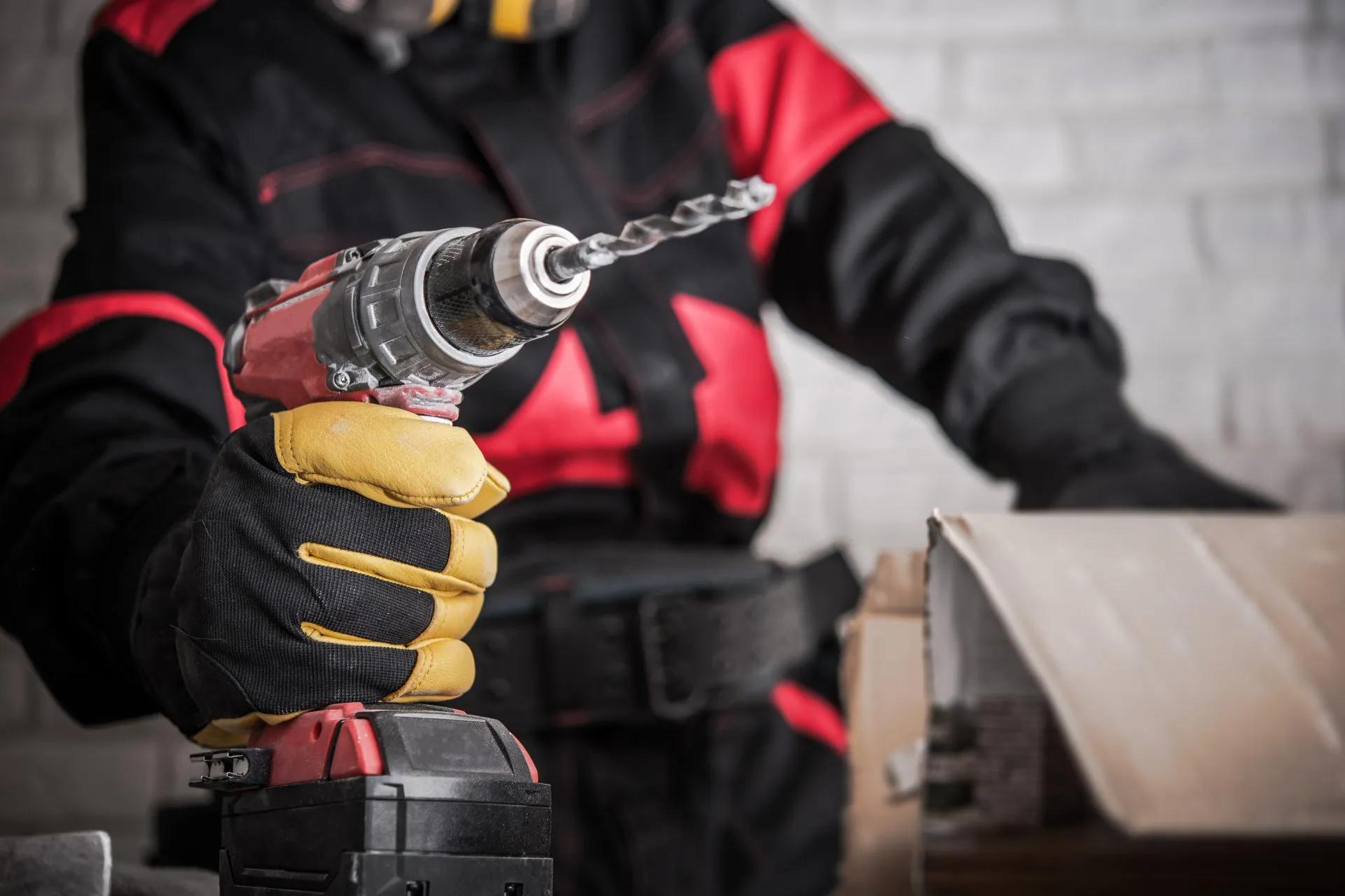 Worker holding a cordless drill with a lithium battery pack