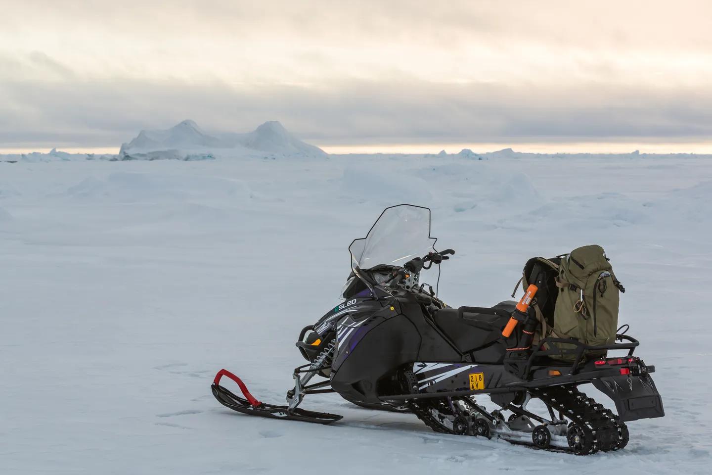 Snowmobile with expedition gear parked on Arctic sea ice