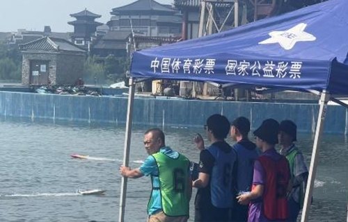 Model ship racing at the National Model Ship Championship, with team members watching from the shore